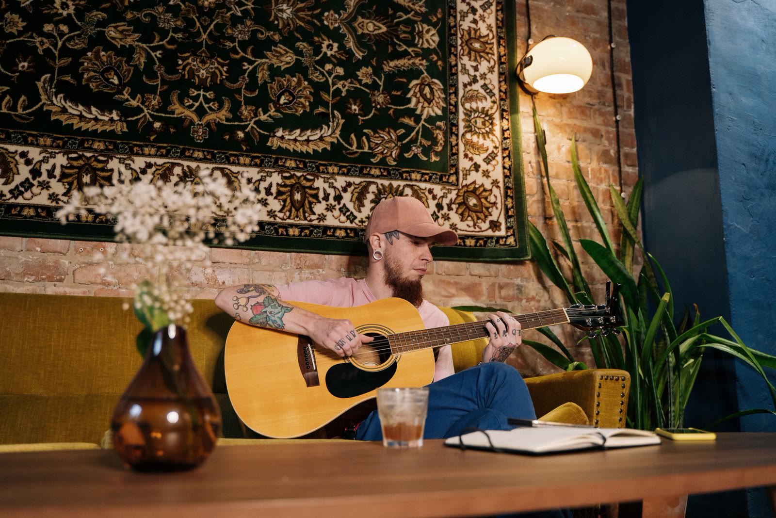 Musician playing acoustic guitar in a cozy room