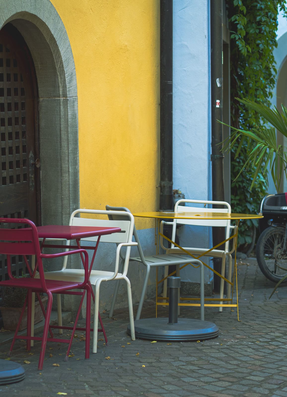 Colorful chairs in front of a sunny yellow wall