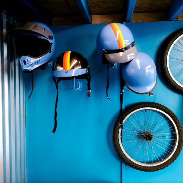 Helmets hanging on a blue wall