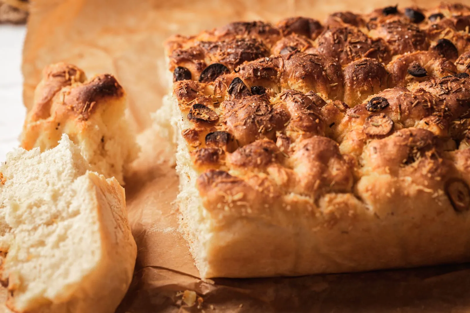 Golden focaccia with olives, torn open