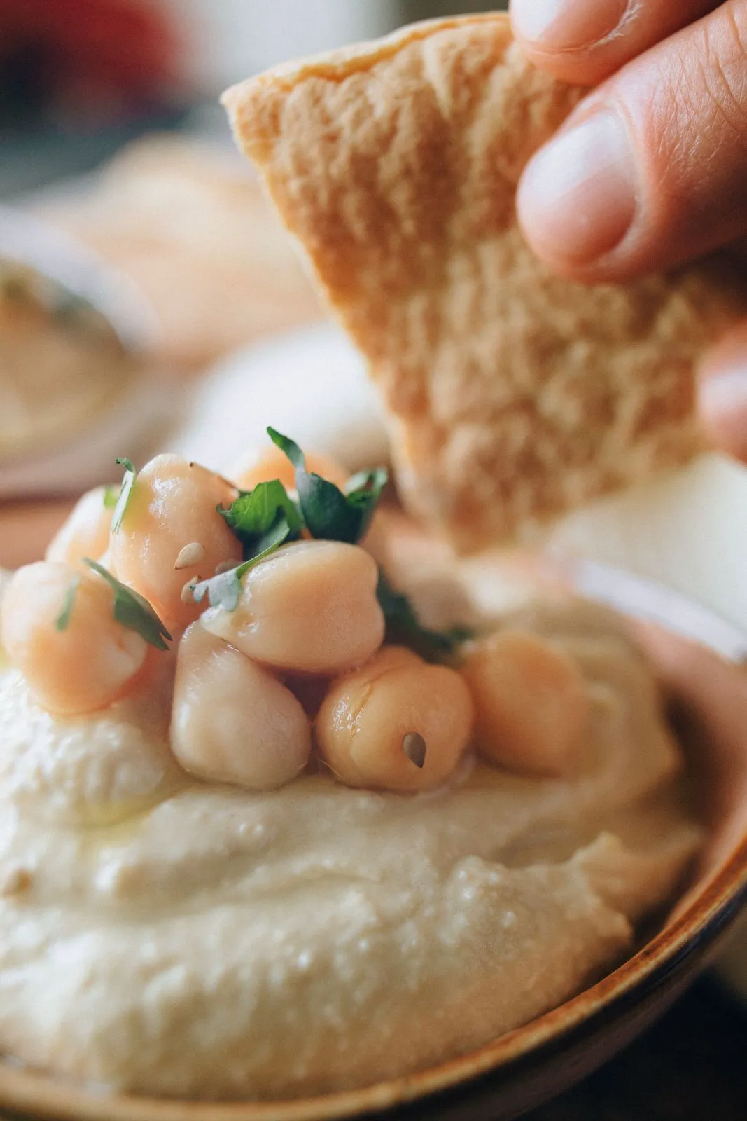 Pita dipped into a spread topped with chickpeas