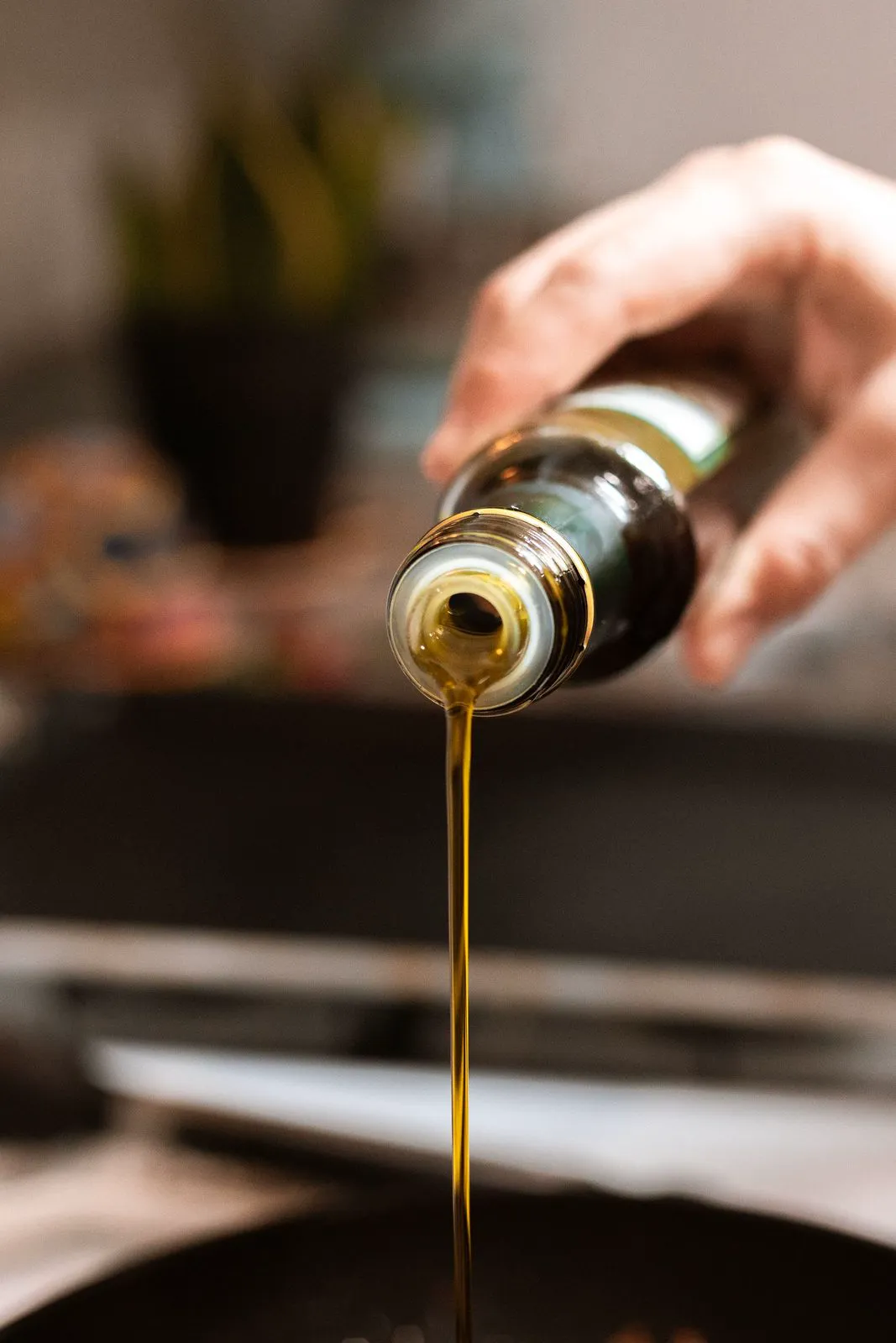 Olive oil poured from a dark bottle