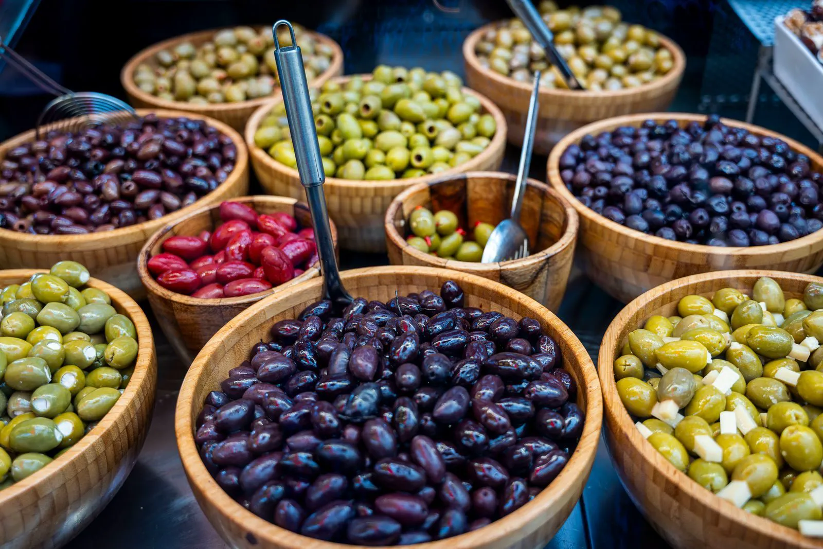 Wooden bowls of green, black and red olives