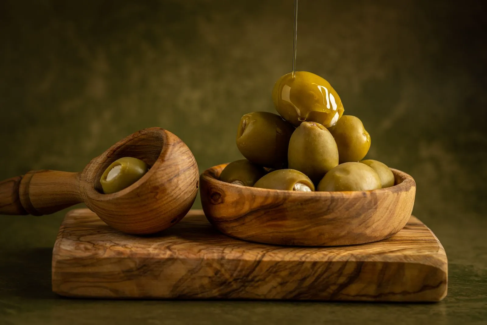Olives in a wooden bowl with olive oil