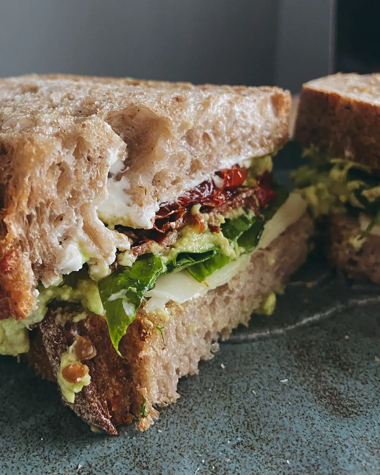 Sourdough sandwich with sun dried tomato, avocado and greens