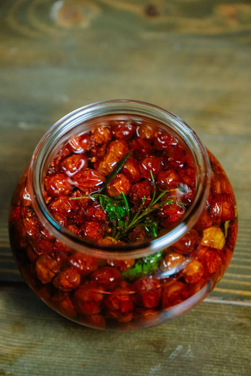 Jar of slow roasted cherry tomatoes in oil with rosemary