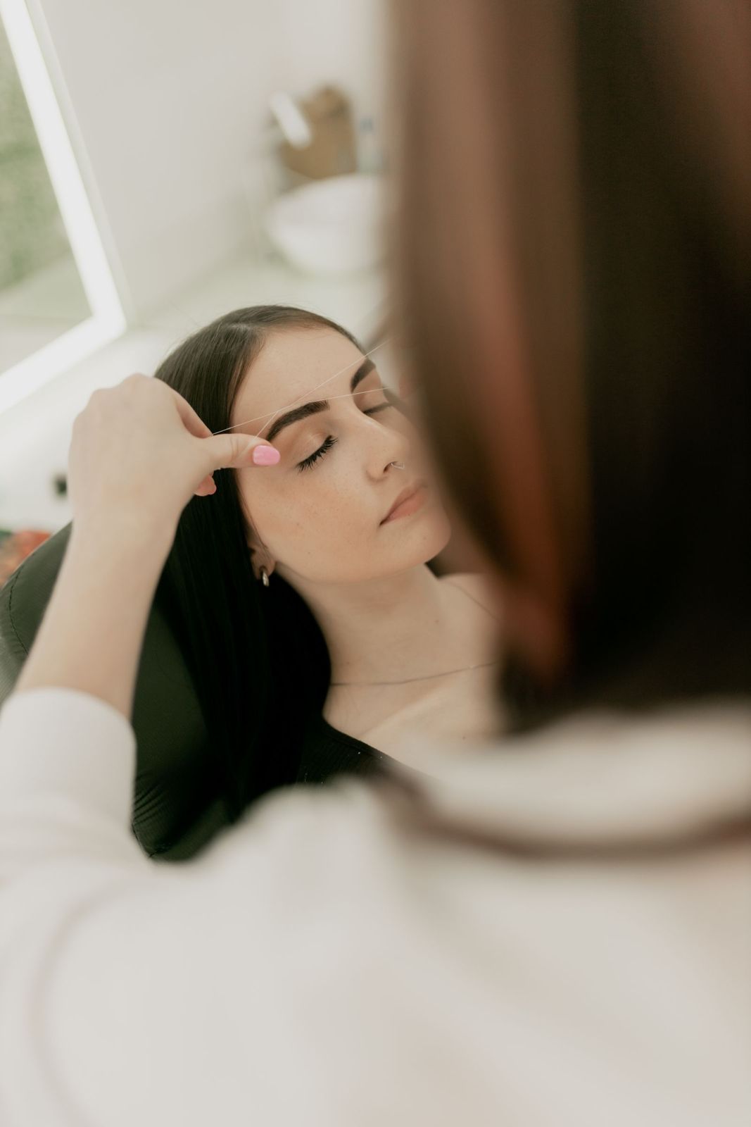 A client relaxing while her brows are mapped