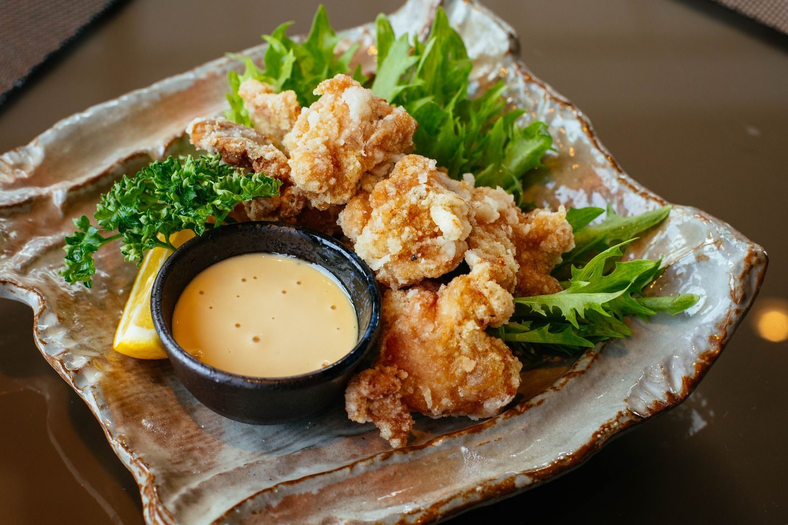 Crispy chicken karaage with greens, lemon and a creamy dipping sauce