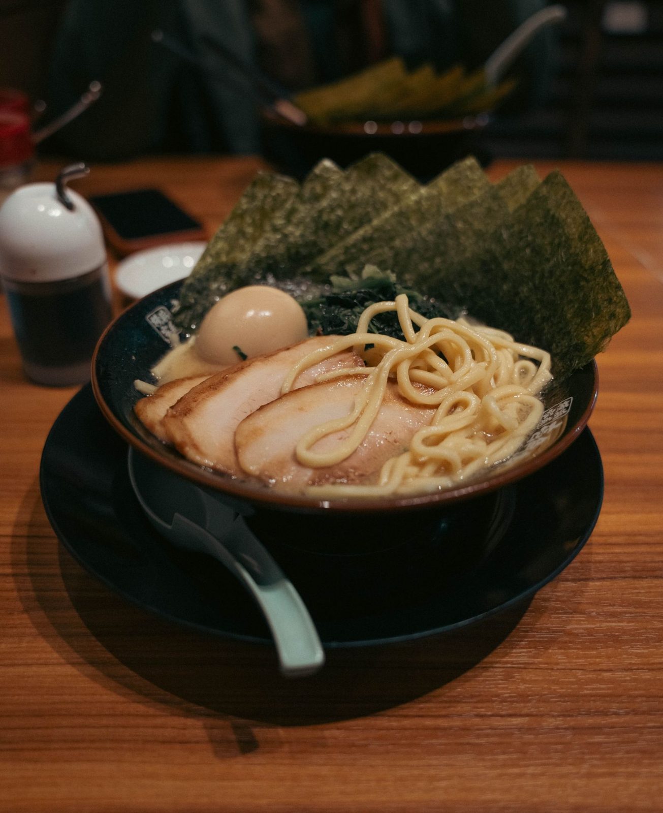 Creamy ramen with chashu, egg and sheets of nori on a wooden table