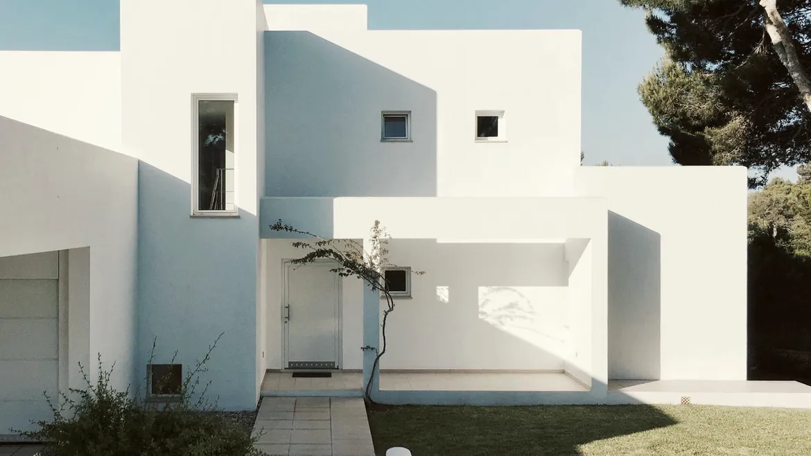 White cubic house behind a garden path