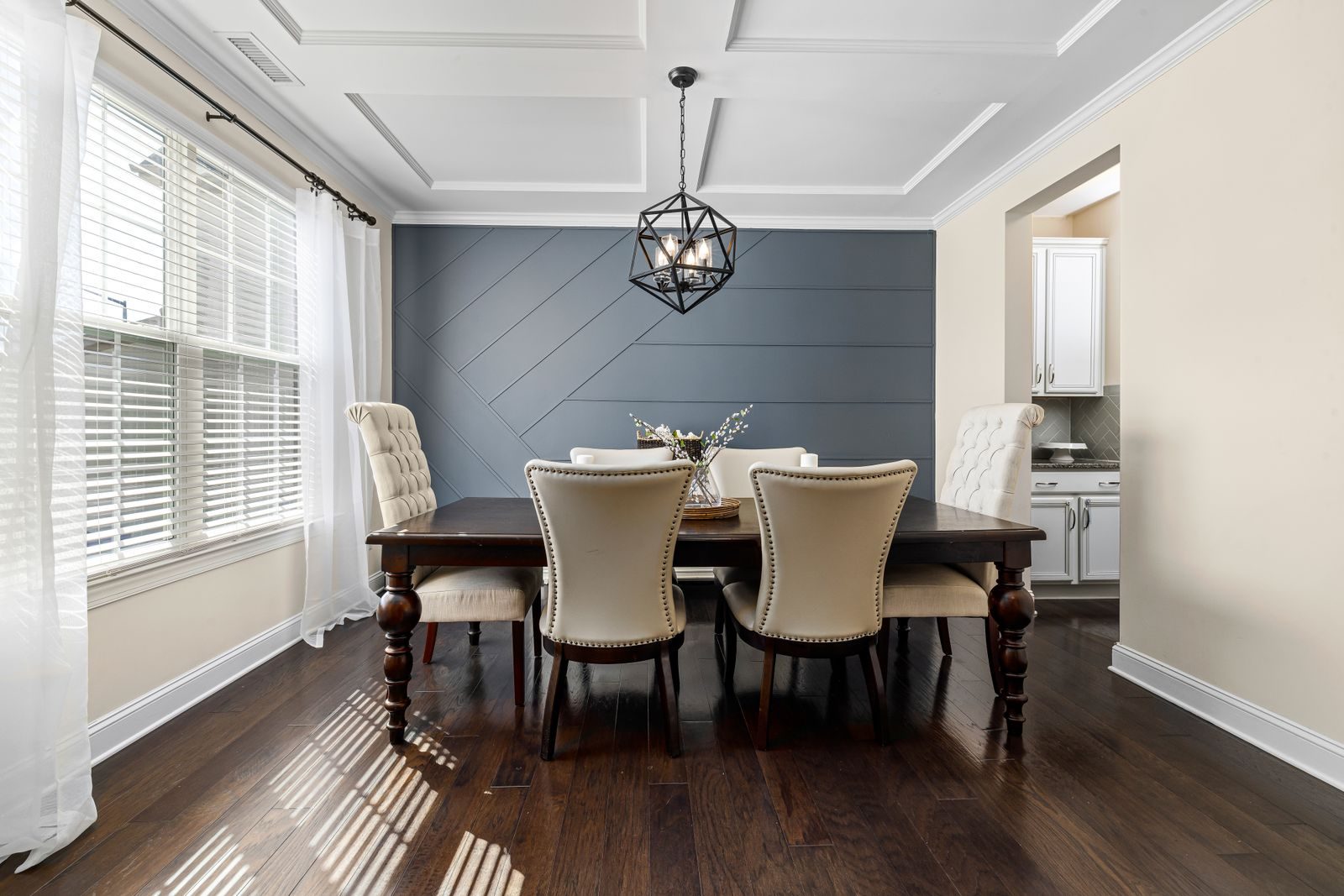 Dining room with a dark stained hardwood floor in afternoon light