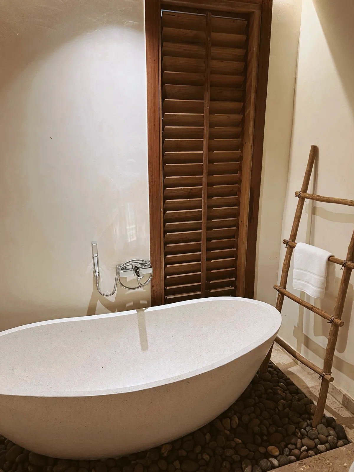Stone bathtub beside wooden shutters