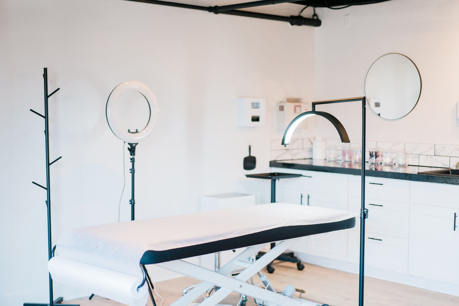 A bright treatment room with a bed and studio lights