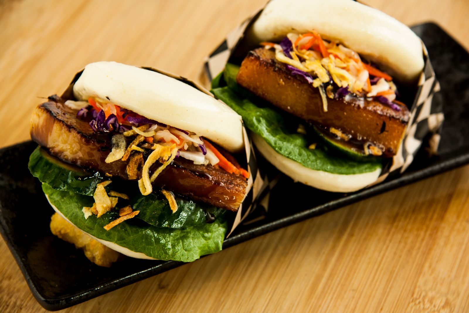 Two pork belly buns with slaw and crispy shallots