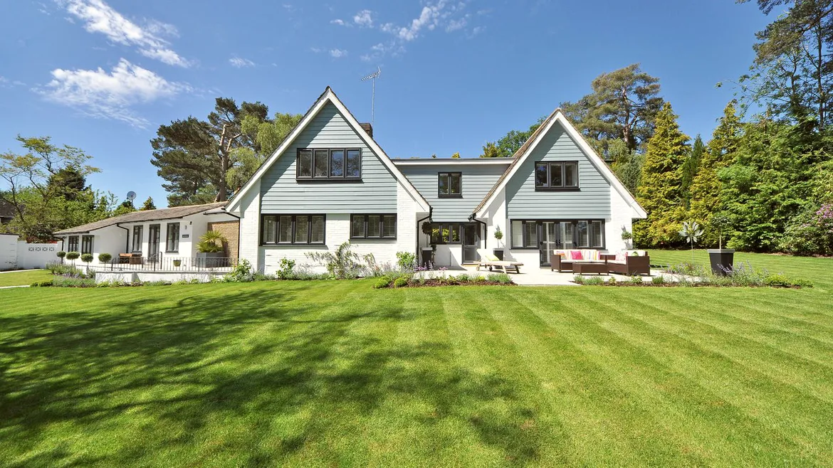Twin gabled house across a striped lawn