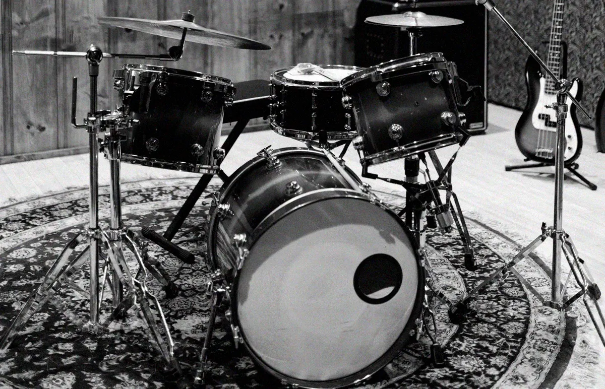 Drum kit on a round rug in a wood panelled live room